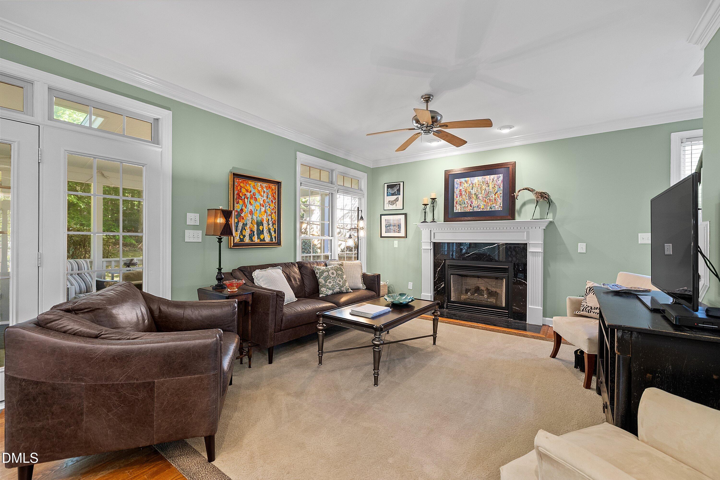 3914 Sterling Ridge Lane Durham, NC 27707 - Photo 14 of 66 Living space featuring a fireplace with a white mantel and dark stone surround, ceiling fan, and double French doors with transom windows