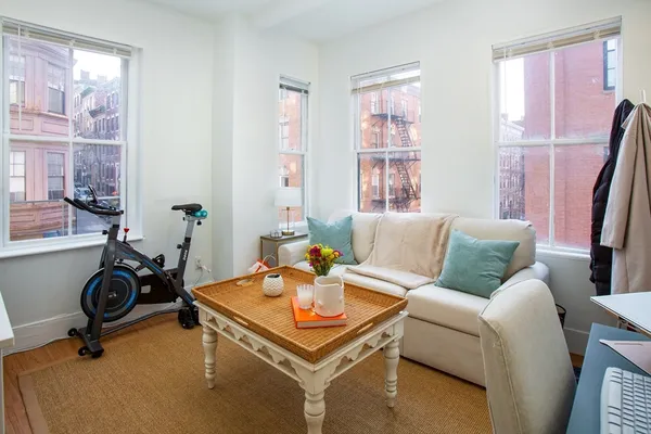 a living room with furniture a window and a flat screen tv