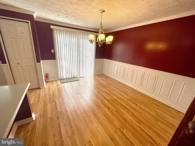 a view of a room with wooden floor staircase and a kitchen space