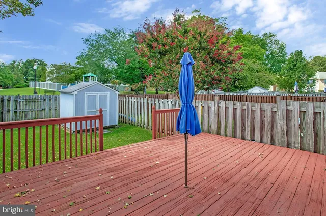 a view of a house with wooden deck and a large window