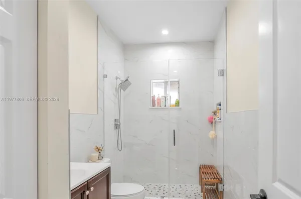 a bathroom with a sink a toilet and shower