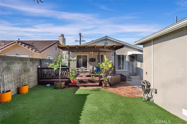 a view of a patio with table and chairs under an umbrella with a small yard