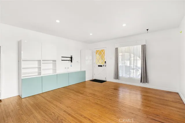 a view of a livingroom with wooden floor and a window