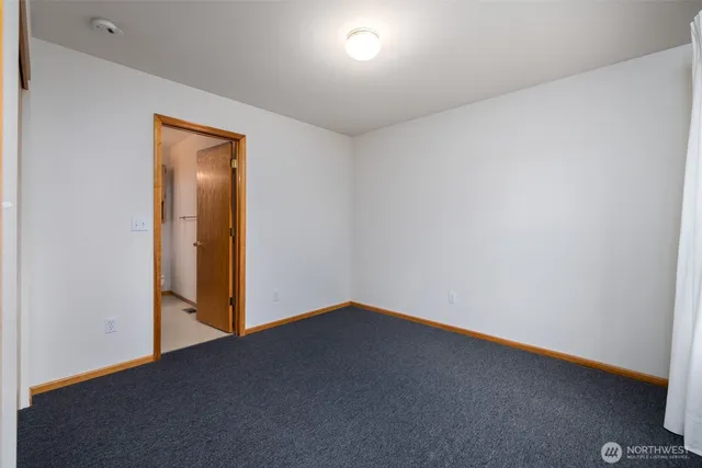 a view of an empty room with closet and a window