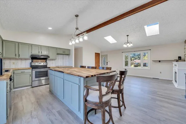 an empty room with wooden floor fireplace and windows