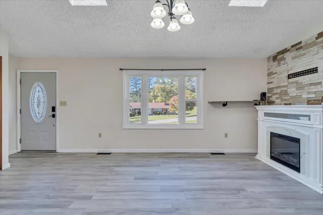 a kitchen with stainless steel appliances granite countertop a dining table chairs refrigerator and cabinets