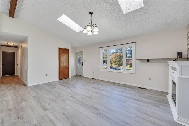 a living room with furniture a fireplace and a chandelier
