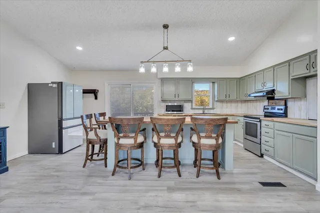a kitchen with a counter space a sink stainless steel appliances and cabinets