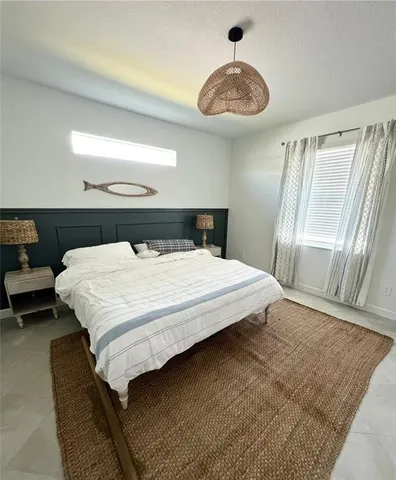 a bedroom with a bed and a chandelier