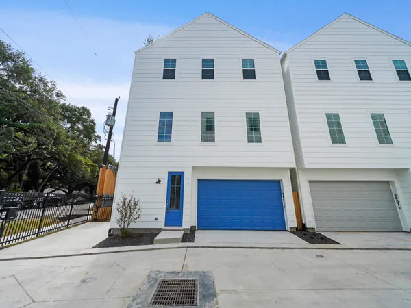 a view of a white building with a yard