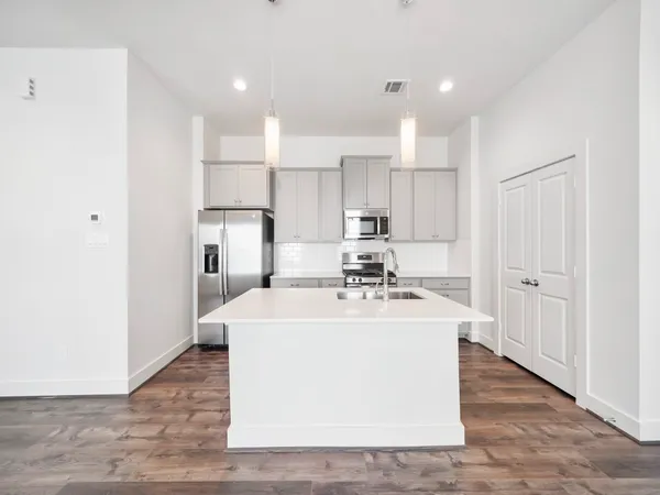 a kitchen with kitchen island a sink stainless steel appliances and cabinets