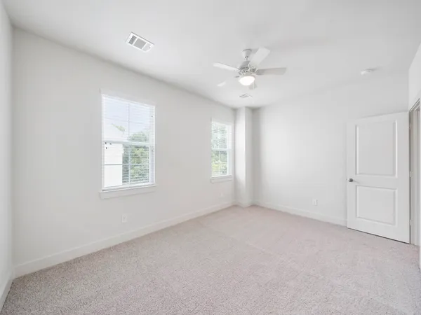 an empty room with a window and a ceiling fan
