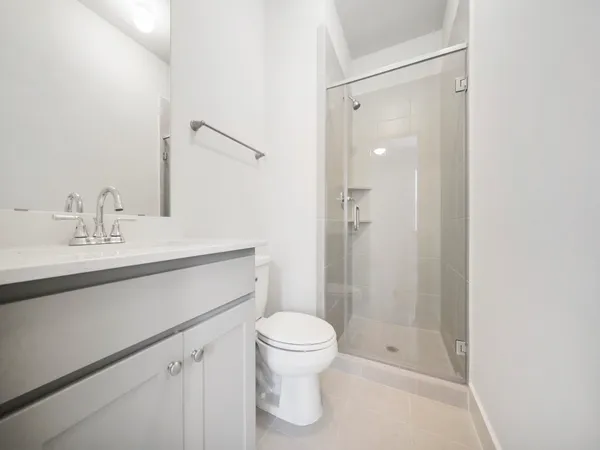 a view of an empty room with a kitchen and a window