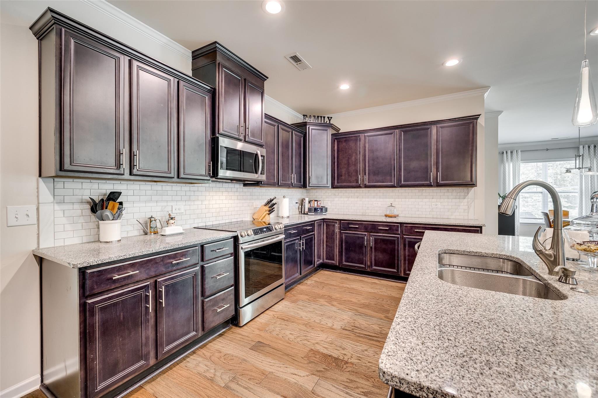 423 Harrier Crossing Circle Fort Mill, SC 29708 - Photo 14 of 36 a kitchen with stainless steel appliances granite countertop a stove sink and cabinets