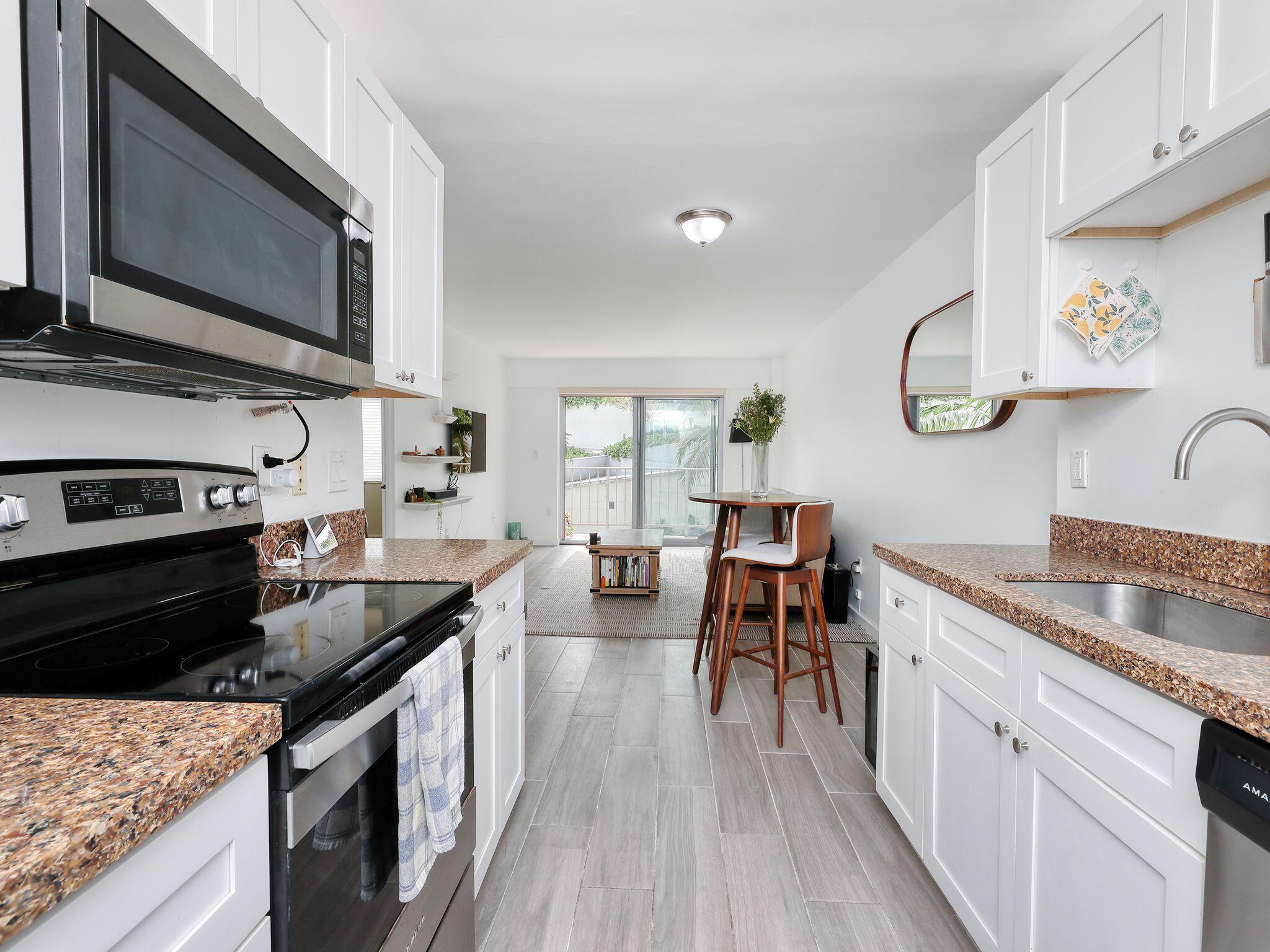 a kitchen with stainless steel appliances granite countertop sink stove top oven and microwave