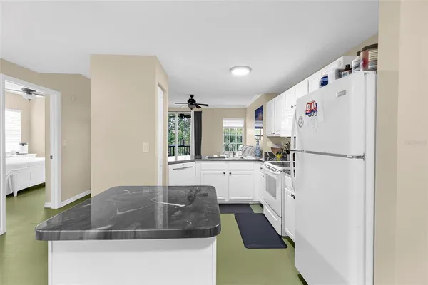 a kitchen with refrigerator a sink and white cabinets