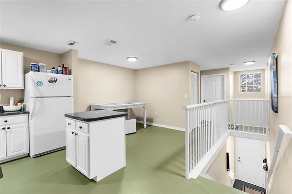 a kitchen with a stove a refrigerator and white cabinets