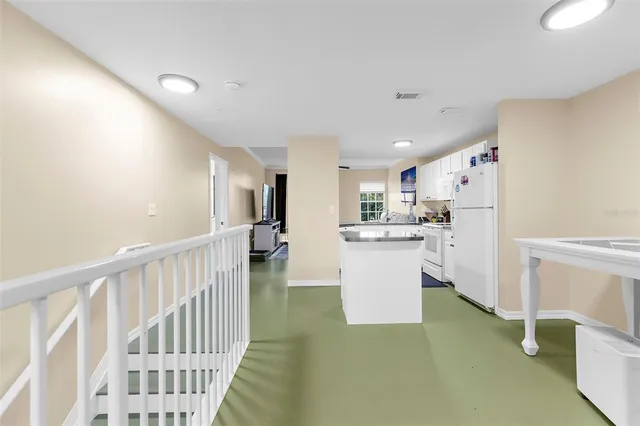 a view of kitchen with furniture and refrigerator