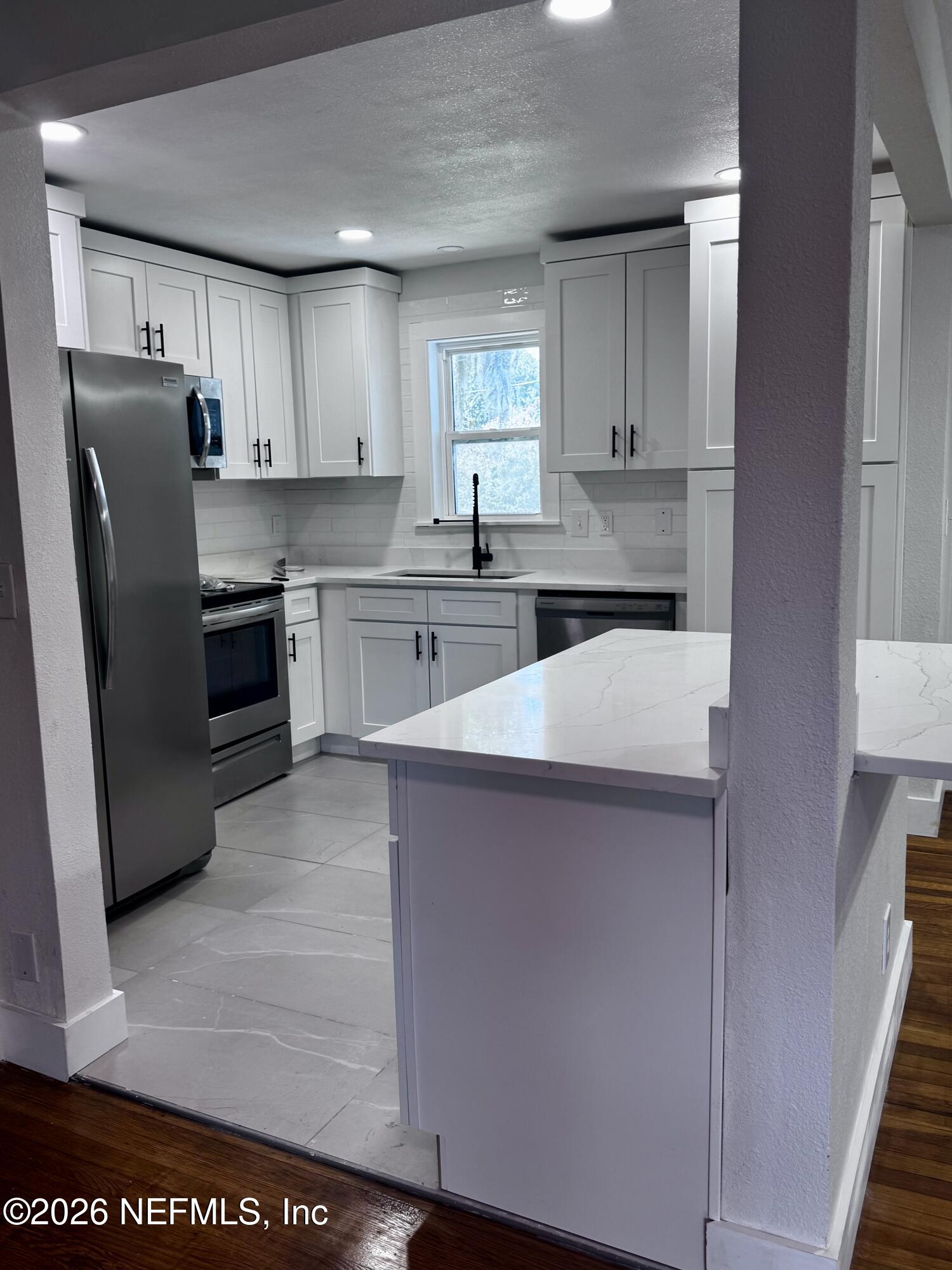 6923 Gaillardia Road South Jacksonville, FL 32211 - Photo 25 of 31 a kitchen with a refrigerator sink and cabinets
