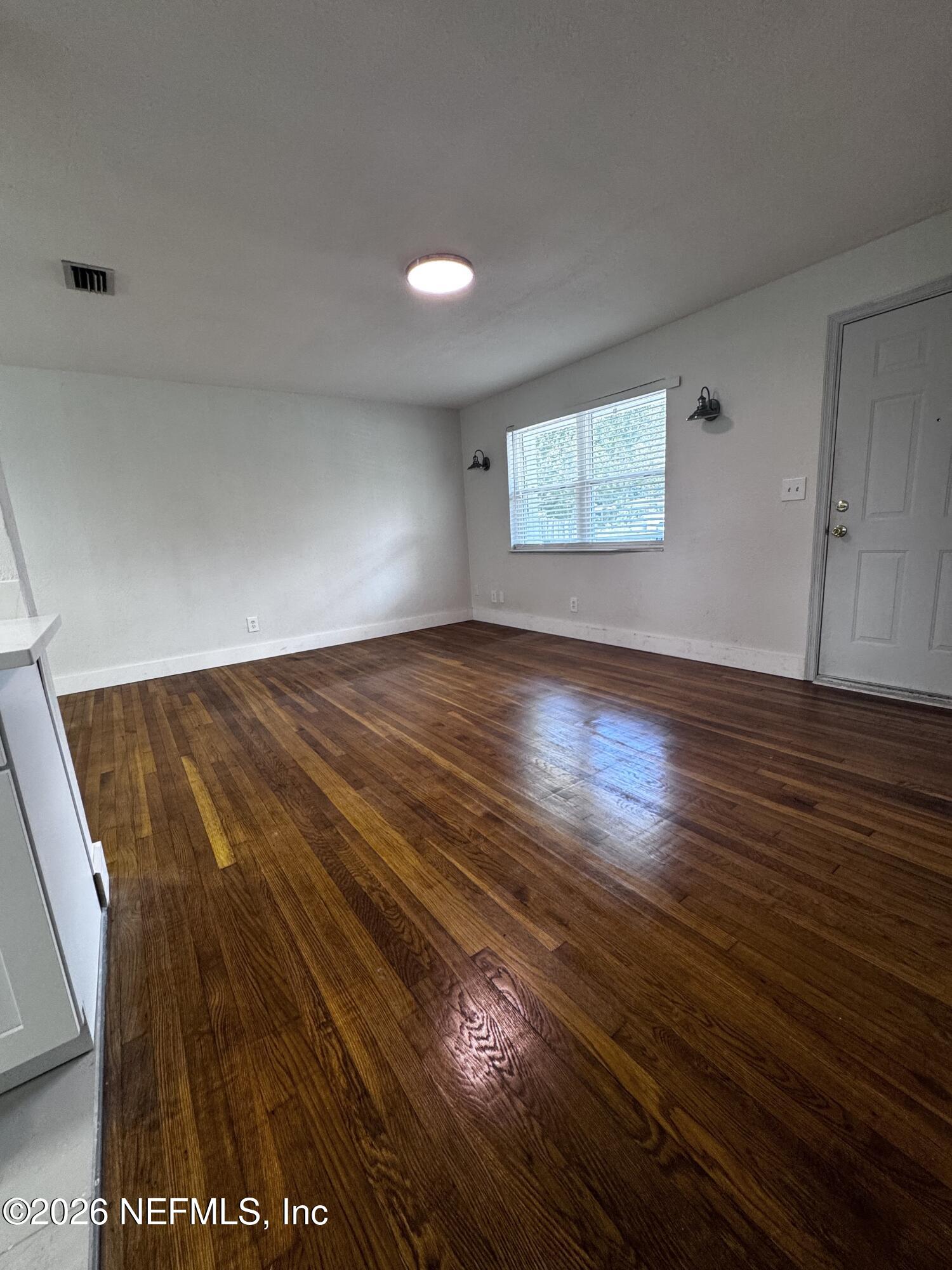 6923 Gaillardia Road South Jacksonville, FL 32211 - Photo 26 of 31 a view of an empty room with wooden floor and a window