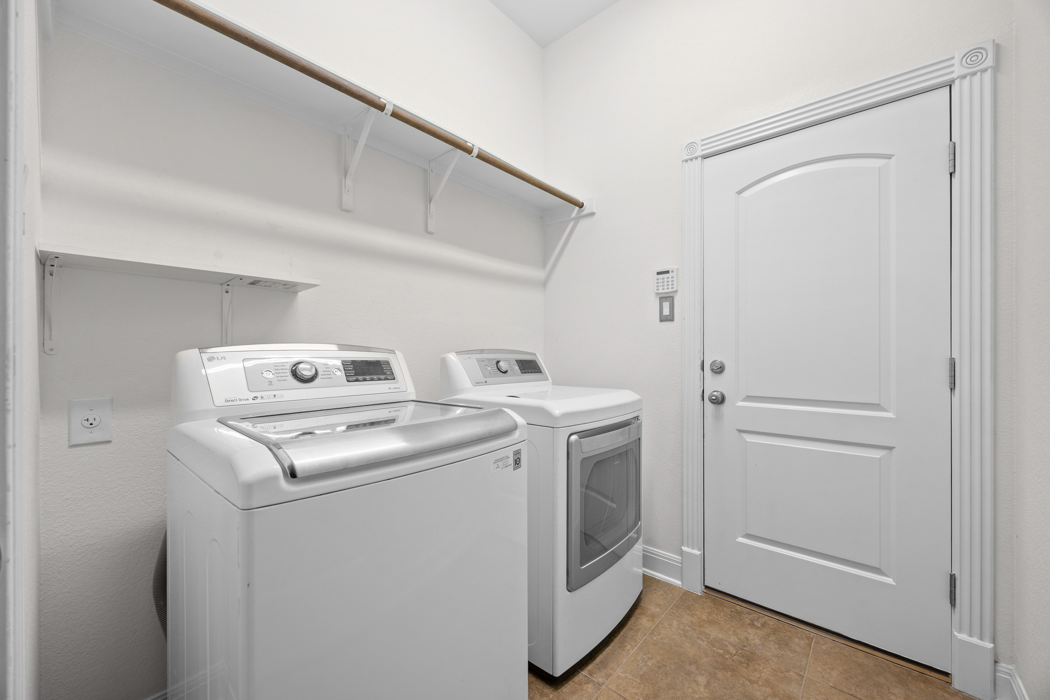 2300 Lakehurst Road Spicewood, TX 78669 - Photo 28 of 40 Laundry area with washing machine and clothes dryer and light tile patterned floors
