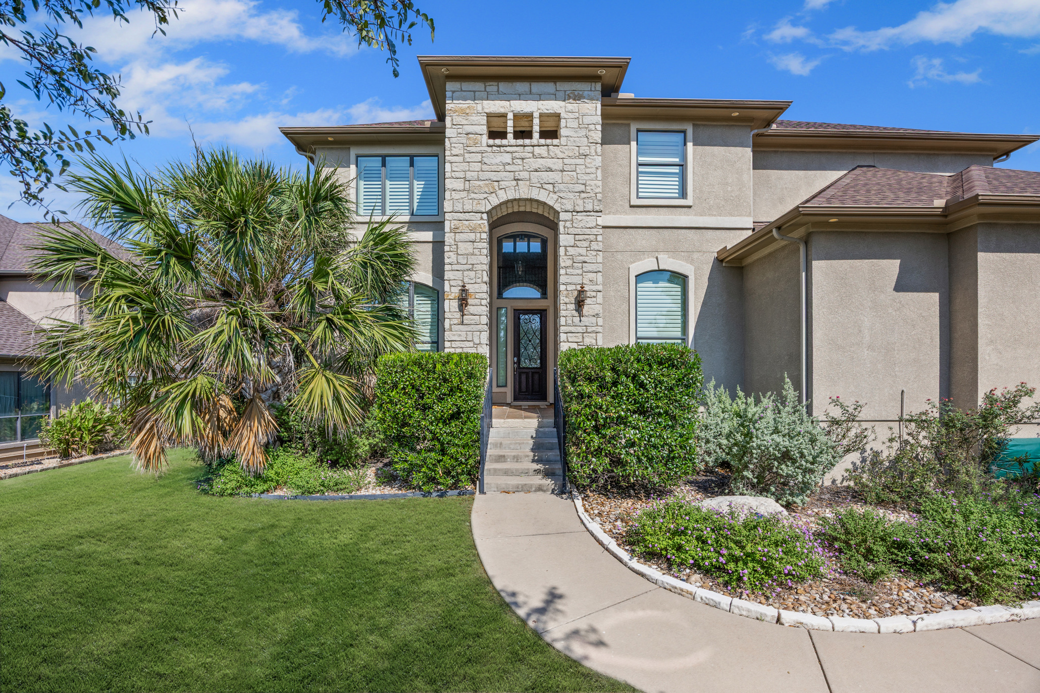 2300 Lakehurst Road Spicewood, TX 78669 - Photo 29 of 40 View of front of house featuring stucco siding, stone siding, and a front lawn