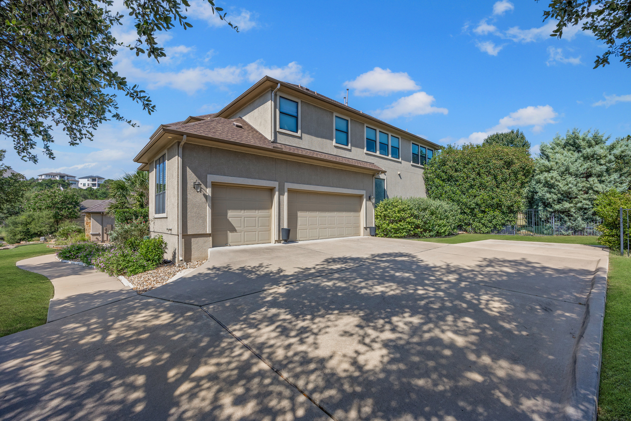 2300 Lakehurst Road Spicewood, TX 78669 - Photo 31 of 40 View of front of house with stucco siding, driveway, and a garage