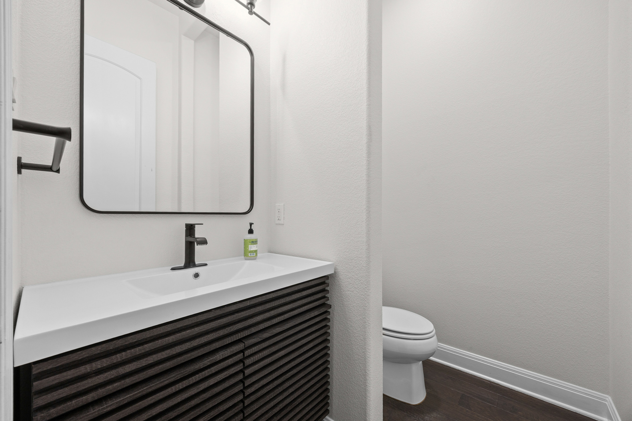 2300 Lakehurst Road Spicewood, TX 78669 - Photo 6 of 40 Half bath featuring vanity and dark wood-style flooring