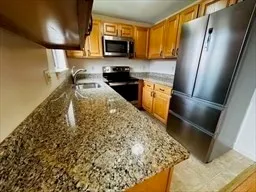 a kitchen with a sink stainless steel appliances a counter top space and cabinets