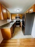a kitchen with stainless steel appliances granite countertop a stove a sink and a refrigerator
