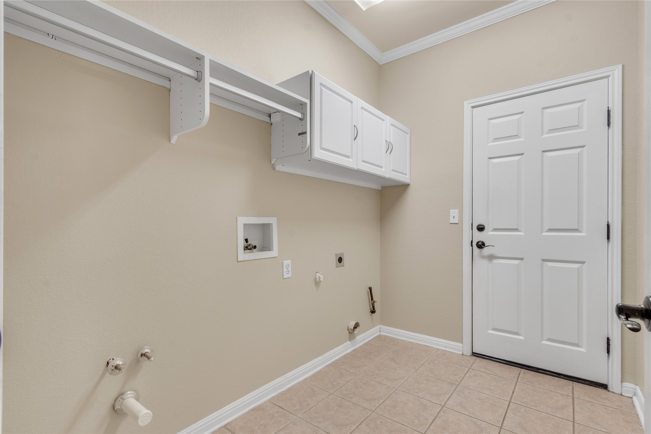 409 Rio Grande Loop Georgetown, TX 78633 - Photo 19 of 34 Laundry room with hookup for a gas dryer, crown molding, washer hookup, cabinet space, and light tile patterned flooring