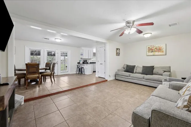 a living room with furniture and a dining table with kitchen view