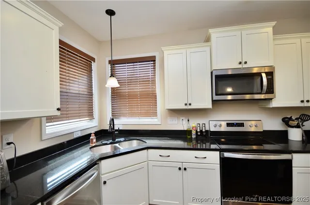 a kitchen with stainless steel appliances a sink a stove and microwave