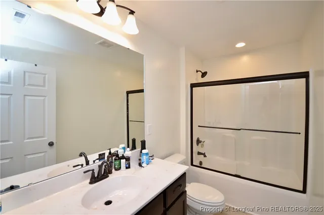 a bathroom with a sink mirror vanity and toilet