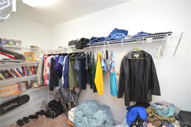 a view of walk in closet with clothes and shoes