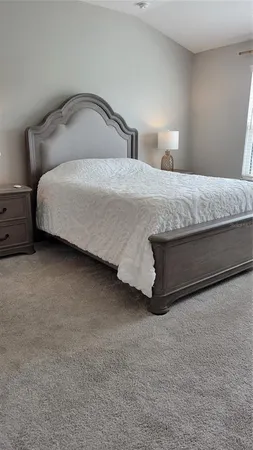 a bedroom with a bed and a night stand