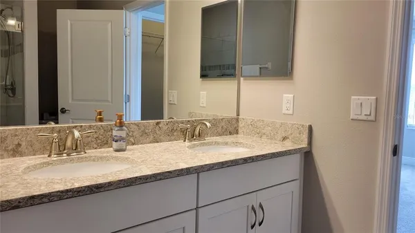 a bathroom with a granite countertop sink and a mirror
