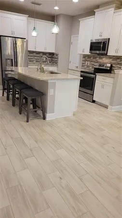 a kitchen with stainless steel appliances kitchen island granite countertop a stove a sink and a refrigerator