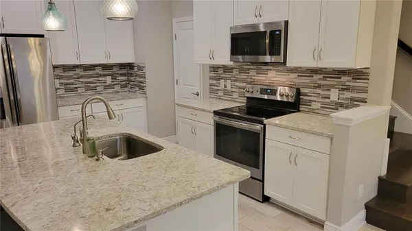 a kitchen with stainless steel appliances granite countertop a sink stove and refrigerator
