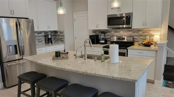 a kitchen with stainless steel appliances granite countertop a sink a stove and microwave
