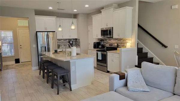 a kitchen with kitchen island white cabinets and stainless steel appliances