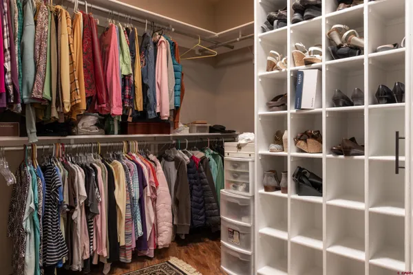 a view of walk in closet with clothes and shoes