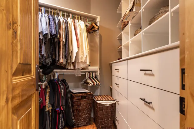 a view of walk in closet with clothes and shoes