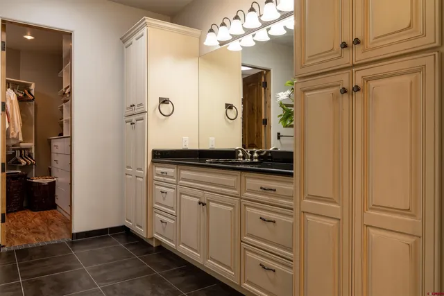 a bathroom with a granite countertop sink a mirror and a shower