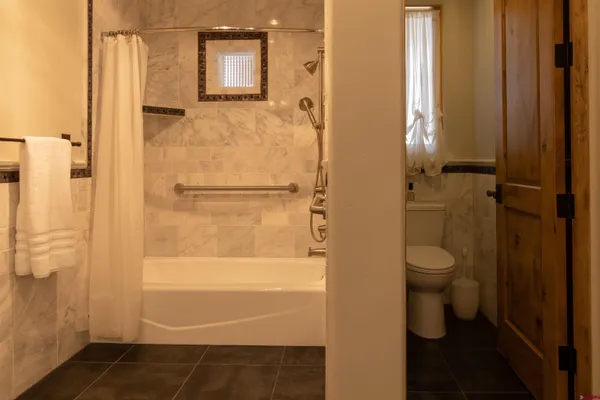 a bathroom with a granite countertop double vanity sink a mirror and shower