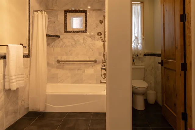 a bathroom with a granite countertop double vanity sink a mirror and shower