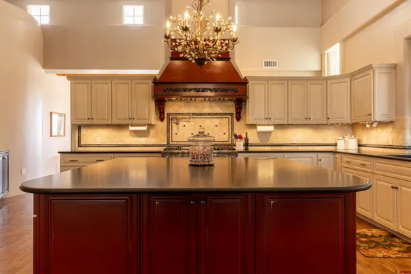 a kitchen with kitchen island granite countertop a sink a counter top space and cabinets