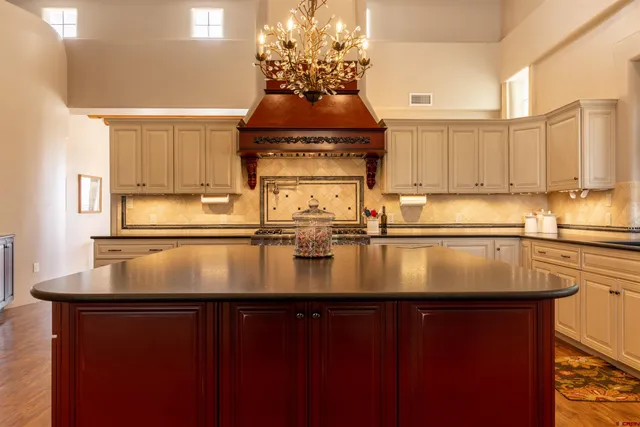 a kitchen with kitchen island granite countertop a sink a counter top space and cabinets