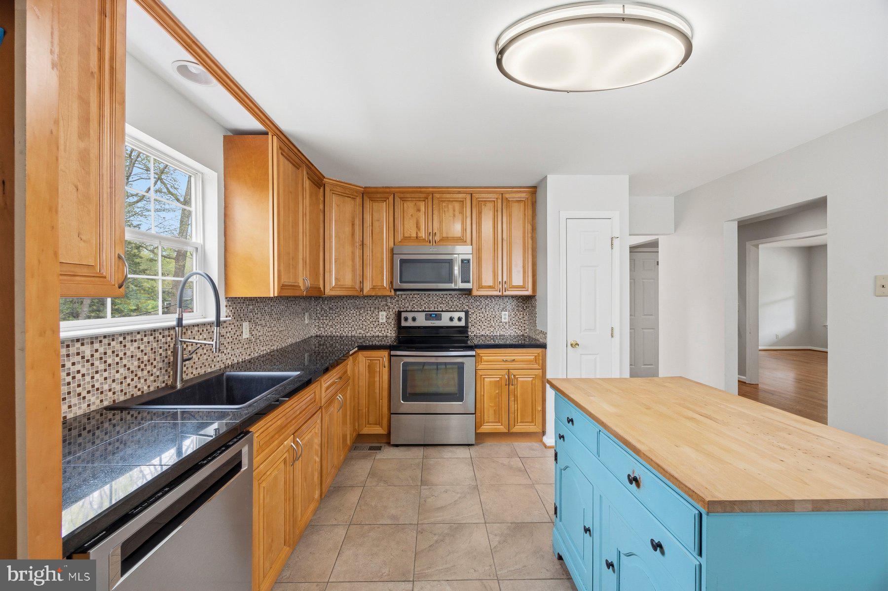 50 Robinson Landing Road Severna Park, MD 21146 - Photo 2 of 38 a kitchen with stainless steel appliances granite countertop a sink counter space cabinets and a large window