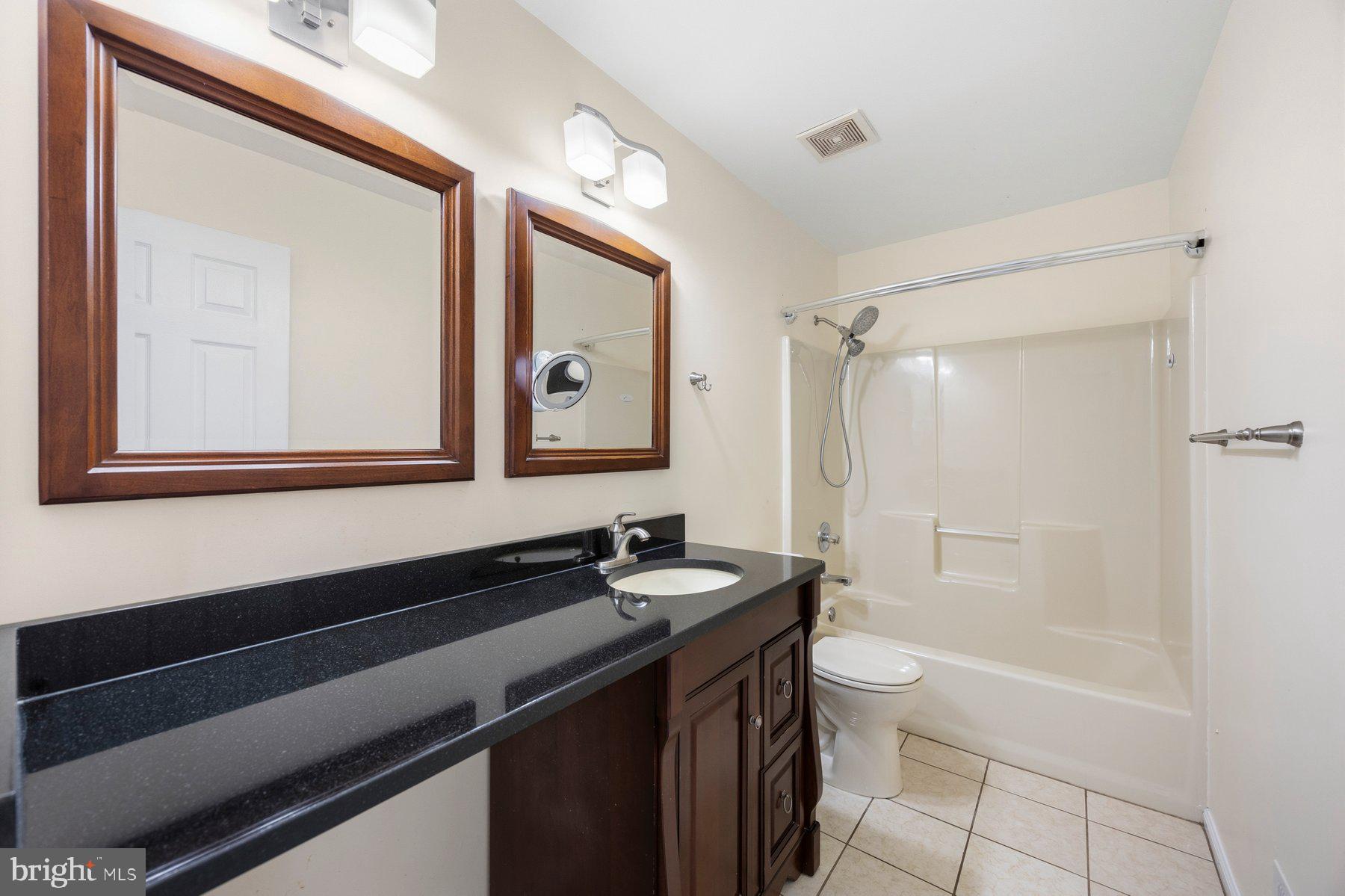 50 Robinson Landing Road Severna Park, MD 21146 - Photo 28 of 38 a bathroom with a granite countertop sink toilet a mirror and shower